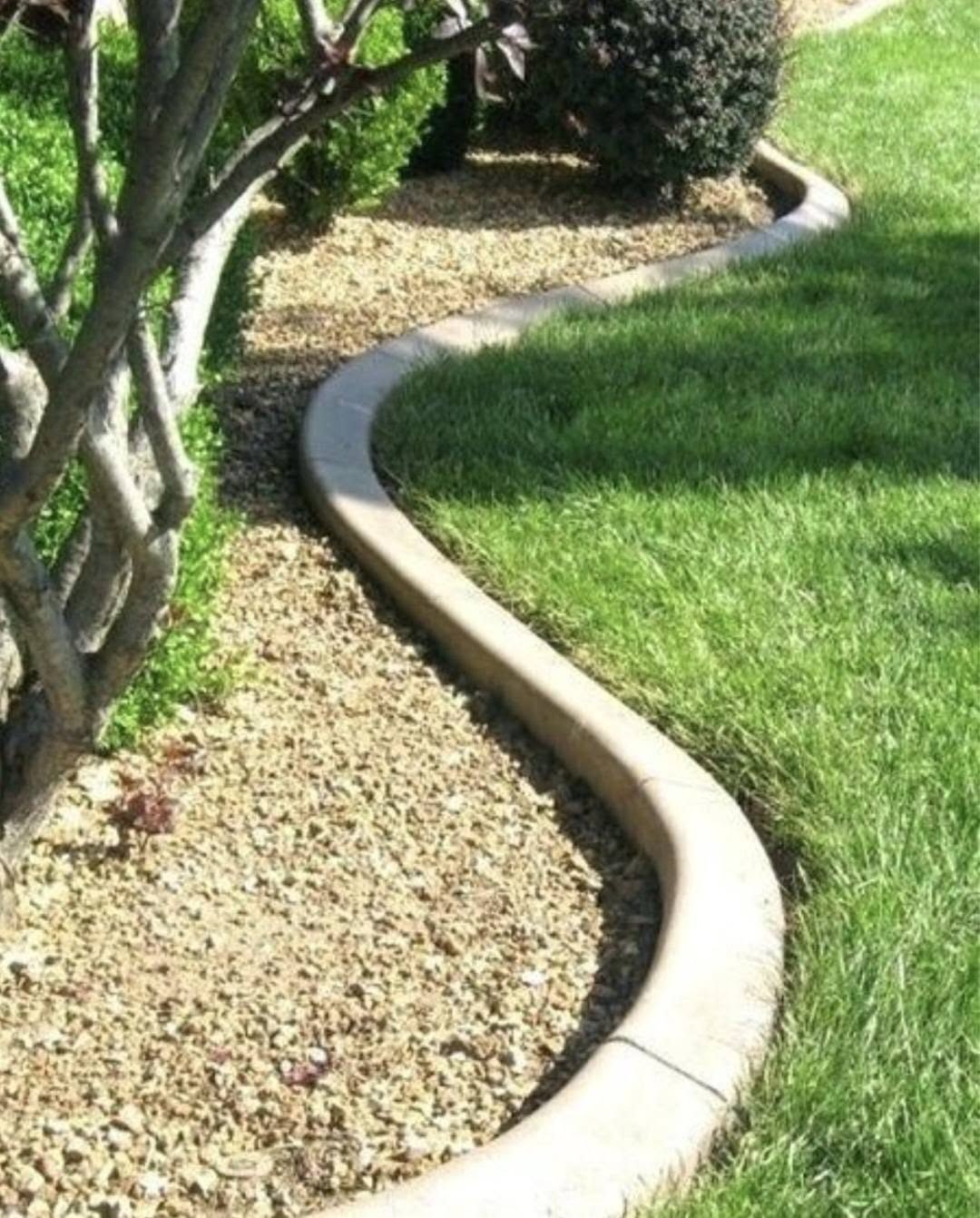 Curved concrete lawn curbing between grass and gravel