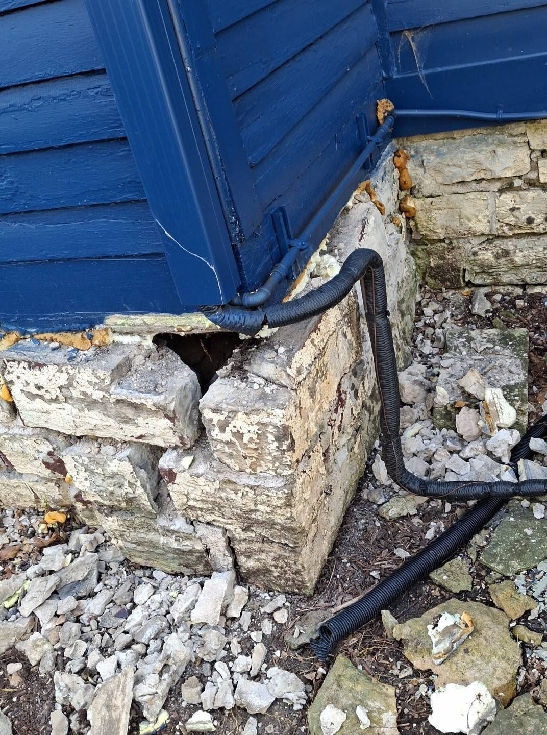 Crumbling limestone foundation corner before repair