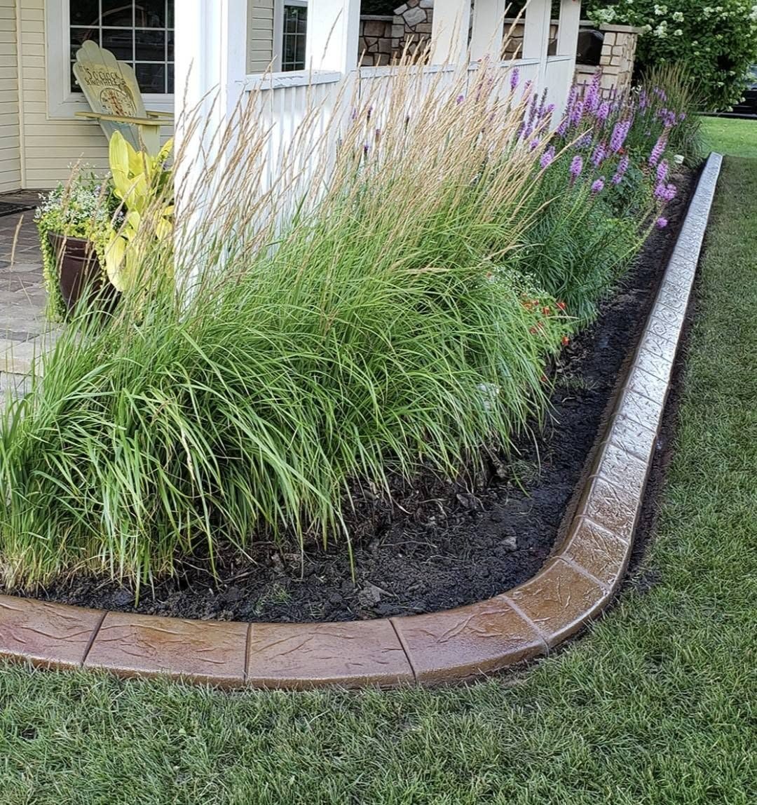 Stamped concrete landscape curbing around a flower bed